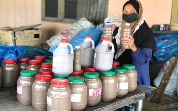 Halimah menunjukkan budu yang diisi ke dalam botol untuk dijual kepada pelanggan yang datang sendiri ke rumahnya di Kampung Pantai Geting.