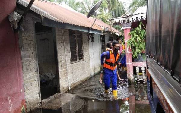 Anggota Angkatan Pertahanan Awam Malaysia (APM) membantu memindahkan mangsa banjir di Changkat Jong. - Foto ihsan APM Perak.