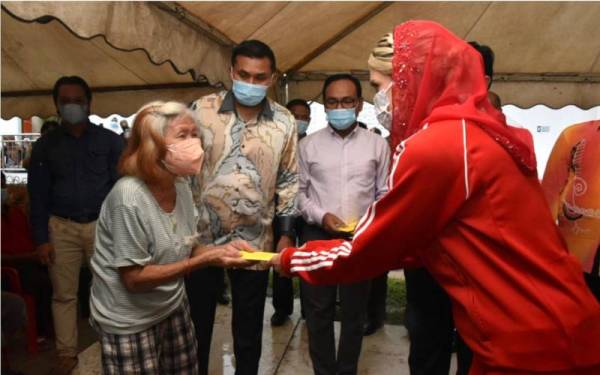 Isteri Tengku Mahkota Kelantan, Cik Puan Sofie Louise Johansson (kanan) mengurniakan sumbangan peribadi wang tunai RM1,000 kepada mangsa kebakaran di Jalan Gajah Mati, Kota Bharu.