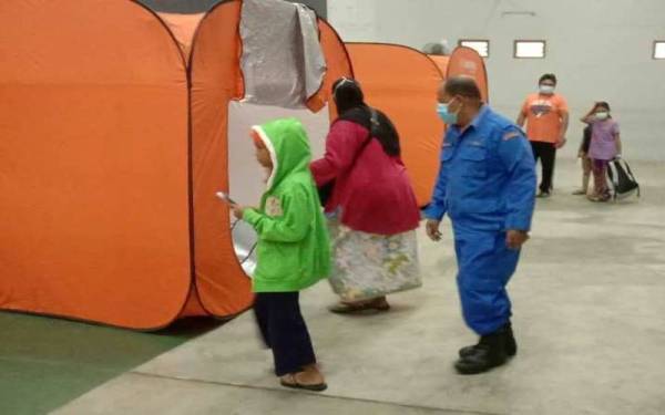 Seorang anggota APM memantau keadaan mangsa banjir yang ditempatkan di PPS Dewan Kg Tradisi Lembah Keriang, Kubang Pasu pada Selasa. - Foto APM Kubang Pasu