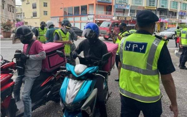 Anggota Unit Operasi JPJ Pahang melakukan pemeriksaan ke atas penunggang motosikal dalam Ops Khas Motosikal di Jalan Penjara pada Rabu. - Foto FB JPJ Pahang