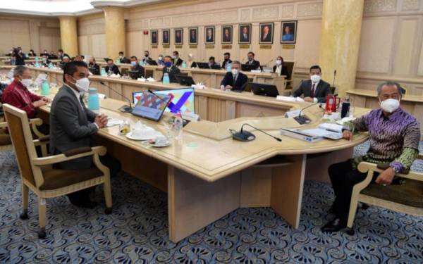 Tan Sri Muhyiddin Yassin (kanan) sebelum mempengerusikan Mesyuarat MPN di Kementerian Kewangan pada Khamis. - Foto Bernama 