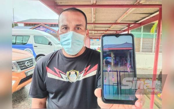 Mohd Azilah menunjukkan keadaan rumahnya yang ditenggelami air sehingga memaksa dia dan keluarga berpindah ke PPS SMK Jelawat.