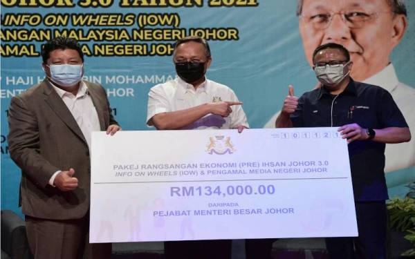 Hasni (tengah) menyampaikan replika cek Pakej Ransangan Ekonomi (PRE) Ihsan Johor 3.0 kepada Pengarah Jabatan Penerangan (JAPEN) Negeri Johor Naim Fahmi Ahmad Tajuddin (kanan) pada Majlis Apresiasi PRE Ihsan Johor 3.0 Tahun 2021 di Kompleks Penerangan dan Penyiaran Sultan Iskandar semalam. Hadir sama Pengerusi Jawatankuasa Pendidikan, Penerangan, Warisan dan Budaya Negeri Johor Mazlan Bujang.- Foto Bernama