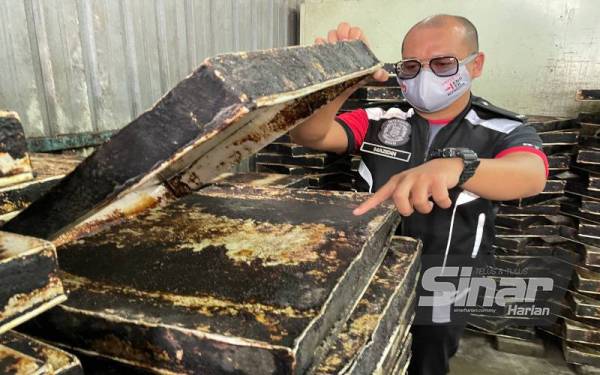 Salah seorang pegawai JKNPP menunjukkan dulang tempat meletak doh roti yang diselaputi minyak tebal dan kotor.