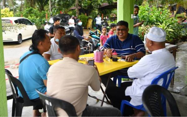 Ab Rauf (dua, kanan) bersarapan bersama penduduk kampung di Taman Bidara Palma dekat Tanjung Bidara pada Rabu. - Foto Bernama