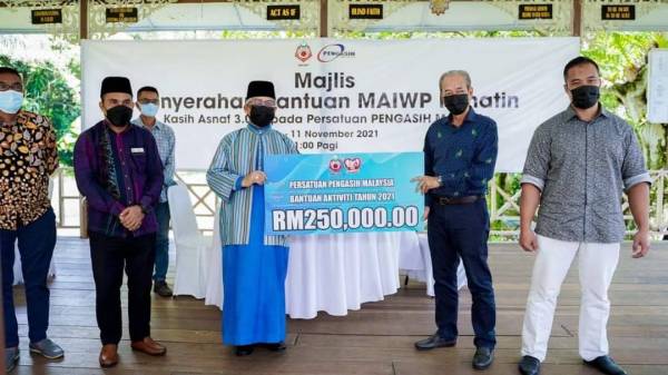 Mohd Ghazali (tiga dari kiri) menyampaikan sumbangan MAIWP kepada Ramli (dua dari kanan).