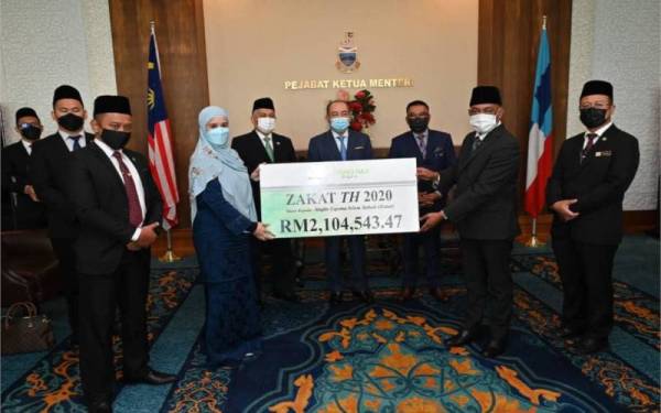 Hajiji (empat dari kanan) bersama Mohd Arifin (lima dari kanan), Safar (tiga dari kanan) menyaksikan penyerahan zakat perniagaan TH daripada Nurlaila kepada Malai Ali. - Foto Facebook TH