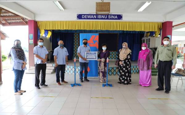 Wakil Bank Rakyat (empat dari kiri) menyerahkan pensanitasi tangan berpedal kepada sekolah terpilih sempena pembukaan sekolah.