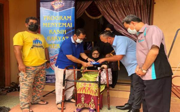 Ruslin (dua dari kanan) menyerahkan Mykad kepada Sehah pada program Mekar dan penyerahan MyKad di Kuala Kangsar.