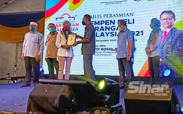 Rosol (tiga dari kanan) menyampaikan Anugerah Kedai Harga Patut (AKHP) kepada peniaga terpilih pada Majlis Perasmian Kempen Beli Barangan Malaysia Peringkat Kebangsaan di Dataran Chenang pada Sabtu.