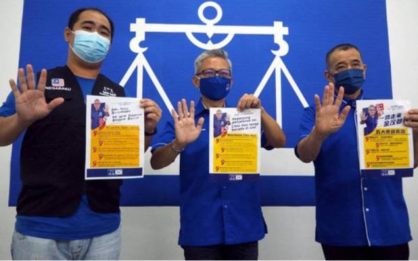 Chin Han (tengah) bersama anggota jentera pilihan rayanya menunjukkan manifestonya selepas sidang media di Bilik Gerakan MCA Jasin pada Sabtu. - Foto Bernama