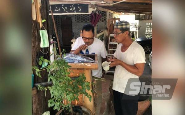 Abdul Majid membantu Engku Abdul Rahman menyedut madu kelulut terus dari sarang ketika berkunjung ke PMC baru-baru ini.