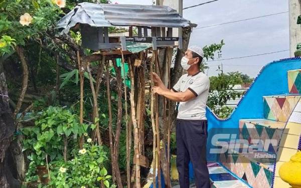 Abdul Majid di samping sarang kelulut berbentuk rumah Telupid yang menjadi antara tarikan pengunjung ke PMC.
