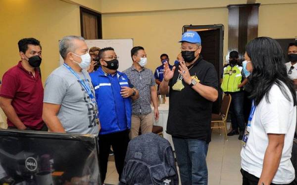 Ketua UMNO Bahagian Ketereh, Tan Sri Annuar Musa (lima ,kiri) beramah mesra dengan petugas bilik operasi Command Center Barisan Nasional (BN) di Dewan Seri Chendana hari ini. - Foto Bernama