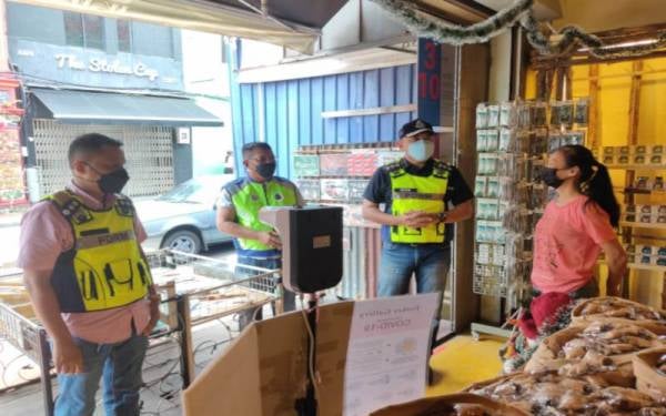 Afzanizar (dua kanan) membuat rondaan pematuhan SOP di Jonker Walk, Melaka Tengah, pada Ahad.