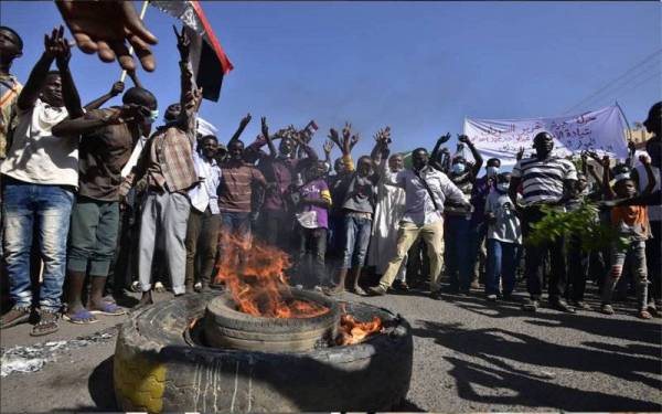 Peserta protes melaungkan slogan mengutuk tentera yang kini memegang kuasa di Khartoum. - Foto AFP