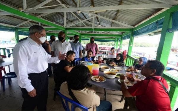 Mustapa beramah mesra dengan pengunjung restoran Asam Pedas Sungai Melayu, Iskandar Puteri, pada Ahad.