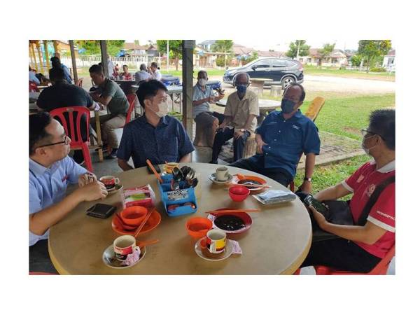 Siong Jiul (dua dari kanan) beramah mesra dengan penduduk Machap Jaya di sebuah kedai makan.