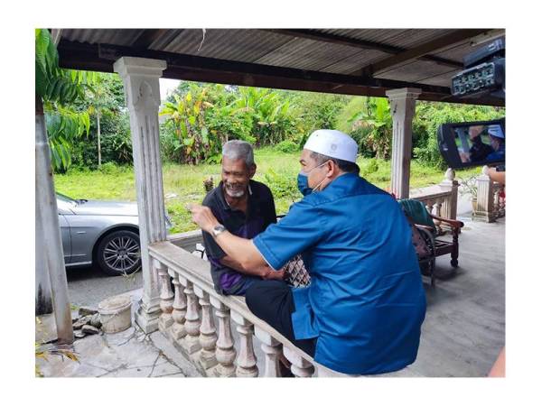 Bakri menyantuni salah seorang penduduk warga emas.