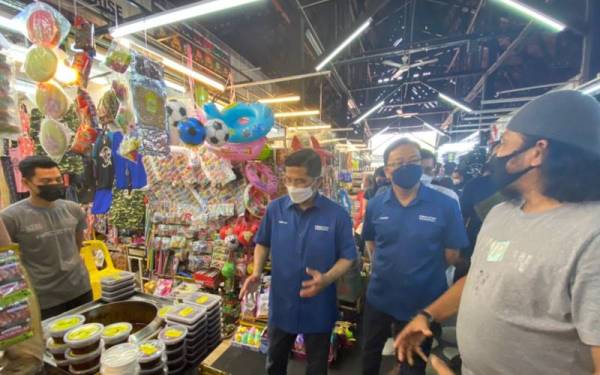 Mohamed Azmin (dua dari kiri) ketika hadir menemui peniaga di Bazar Ole-Oleh Melaka, Bandar Hilir pada Selasa