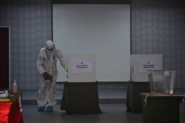 Petugas SPR melakukan kerja-kerja sanitasi di pusat mengundi pada hari mengundi awal Pilihan Raya Negeri Melaka 2021 ketika tinjauan di Kem Bukit Beruang hari ini. -Foto Bernama