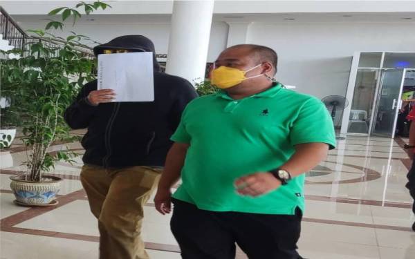 Mohamad Zarir (kiri) keluar dari Mahkamah Sesyen Alor Setar selepas didakwa atas tiga pertuduhan menyelahgunakan wang bantuan membaiki rumah pada Selasa.