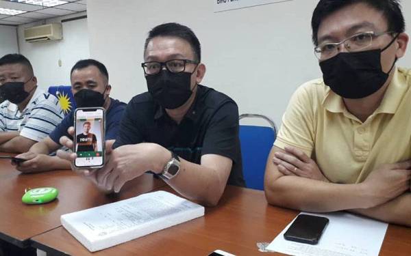 Thow Siang (dua dari kanan) menunjukkan mesej dan ugutan menerusi panggilan suara daripada ah long Singapura dikenali sebagai Sky selepas sidang akhbar di Pejabat MCA Pasir Gudang, Johor Jaya, Johor Bahru pada Selasa.