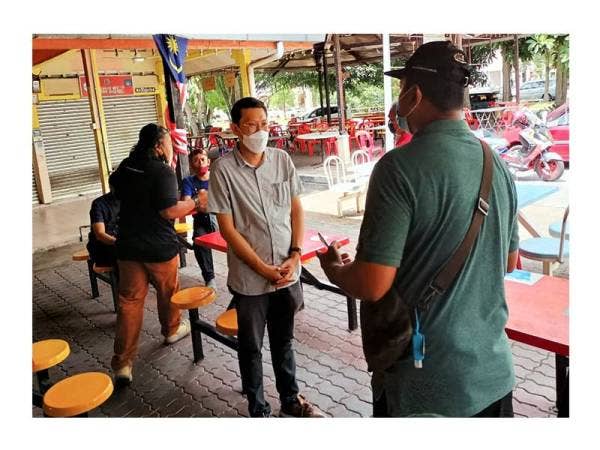Patrick (kiri) menyantuni pengundi sewaktu singgah makan di salah sebuah kedai di Kesidang.