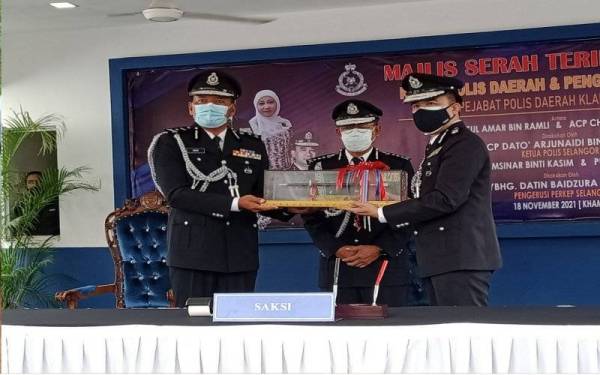 Shamsul Amar (kiri) bersama Hoong Fong (kanan) menyerahkan tongkat sebagai simbolik serah terima tugas sambil disaksikan Ketua Polis Selangor, Datuk Arjunaidi Mohamed dalam majlis yang diadakan di IPD Klang Selatan pada Khamis.