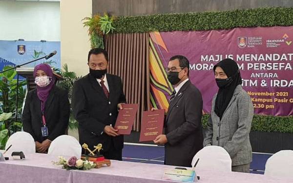 Ismail Ibrahim (dua dari kanan) menunjukkan dokumen MoU antara IRDA dan UiTM Kampus Pasir Gudang berhubung pembangunan modal insan dalam satu majlis di UiTM Pasir Gudang pada Khamis.