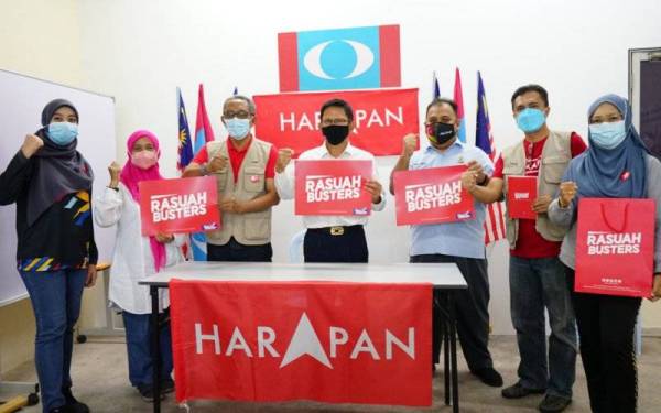 Gue Teck (tengah) dan petugas bilik gerakannya menunjukkan sokongan kepada Rasuah Busters.