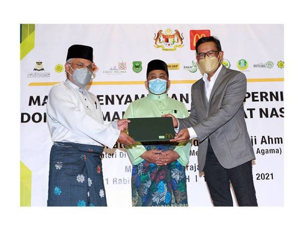 Azmir (kanan) menyerahkan zakat perniagaaan kepada wakil 14 agensi pungutan zakat yang disaksikan oleh Ahmad Marzuk (tengah) pada majlis Penyampaian Zakat Perniagaan McDonald's Malaysia Peringkat Kebangsaan 2021, di Putrajaya pada Selasa. 