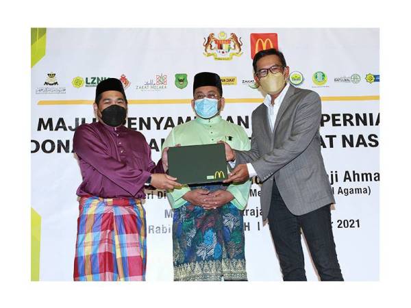 Azmir (kanan) menyerahkan zakat perniagaaan kepada wakil 14 agensi pungutan zakat yang disaksikan oleh Ahmad Marzuk (tengah) pada majlis Penyampaian Zakat Perniagaan McDonald's Malaysia Peringkat Kebangsaan 2021, di Putrajaya pada Selasa. 