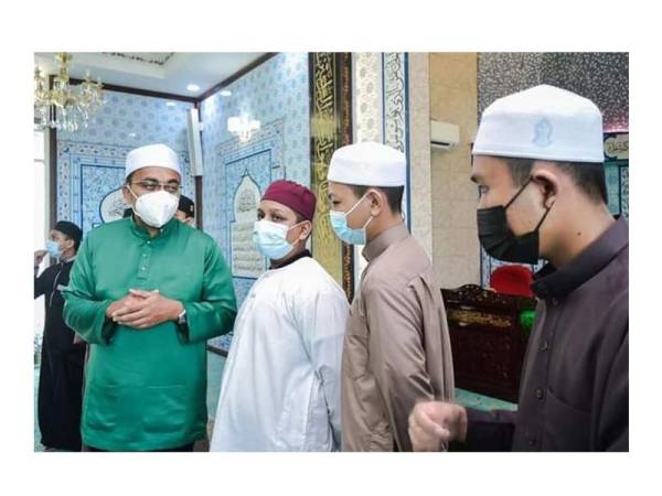 Mohd Rafiq (kiri) sempat berbual dengan jemaah masjid selepas menunaikan solat berjemaah.