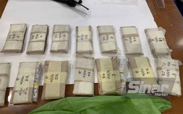 Bungkusan surat khabar yang berisi 10 botol heroin setiap satu yang berjaya dirampas.