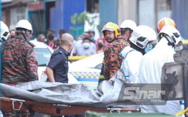 Anggota Bomba dan Penyelamat mengeluarkan mayat mangsa rentung dalam kebakaran di sebuah bengkel kenderaan di Bukit Puchong di sini pada Jumaat - FOTO SINAR HARIAN/ ROSLI TALIB