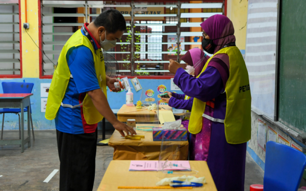 Petugas Suruhajaya Pilihan Raya (SPR) membuat persiapan akhir di pusat mengundi di Sekolah Kebangsaan Jeram bagi Pilihan Raya Negeri Melaka hari ini.- Foto Bernama