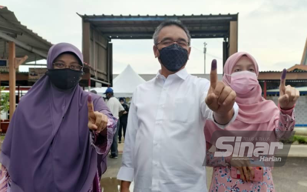 Adly berkemeja putih bersama isteri, Dalilah Awaluddin dan anak sulong mereka Izny Adly berusia 24 tahun selesai mengundi.