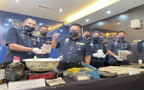 Mustafa (tiga dari kiri) menunjukkan dadah dan peralatan memproses dadah pada sidang akhbar di Ibupejabat Polis Kontinjen Pulau Pinang pada Sabtu.