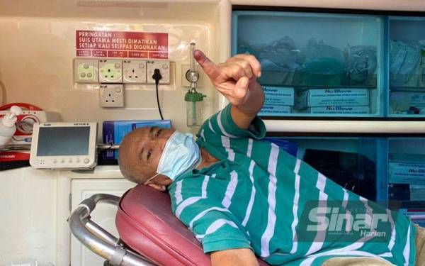 Abdul Rahim menunjukkan kesan dakwat menandakannya telah selesai mengundi bagi DUN Lendu pada Sabtu.