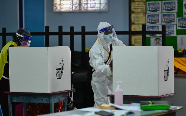 Petugas pembersihan melakukan kerja-kerja sanitasi di bilik mengundi pada Pilihan Raya Negeri (PRN) Melaka 2021 di Sekolah Kebangsaan Durian Daun (K) hari ini.- Foto Bernama