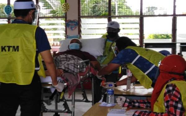 Petugas SPR membantu Tawab dalam proses pembuangan undi.