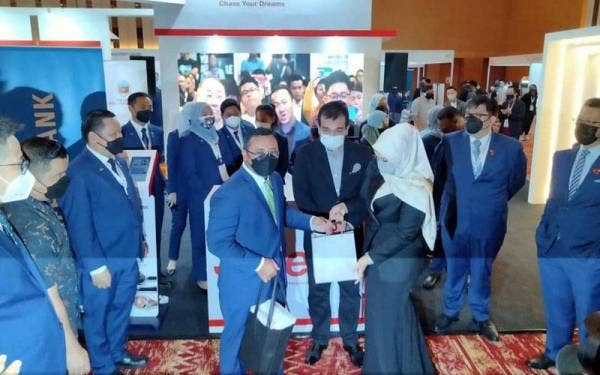 Siti Nurhaliza (kanan) menyampaikan cenderahati kepada Amirudin.