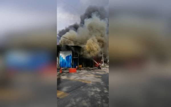 Anggota bomba memadam kebakaran kedai runcit di Jalan Teratai Utama, Paya Jaras di sini pada petang Sabtu.