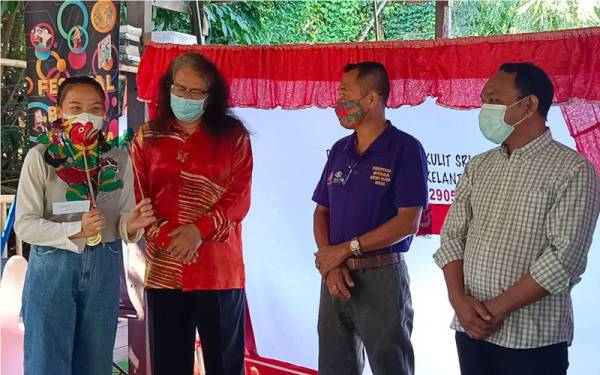 Swee Tin (tiga dari kanan) beramah mesra dengan peserta bengkel membuat patung wayang kulit plastik anjuran Balai Seni Visual Negara dengan kerjasama Persatuan Wayang Kulit Sri Cindayu di Kubang Kerian, Kota Bharu pada Sabtu.