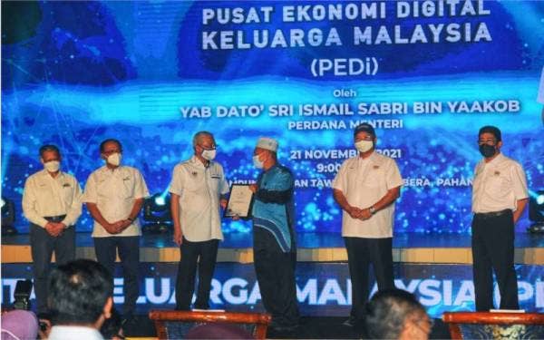 Ismail Sabri (tiga, kiri) menyampaikan Sijil Rakan Digital PEDi kepada peserta terlibat sempena pelancaran PEDi di Kampung Durian Tawar di Bera pada Ahad.