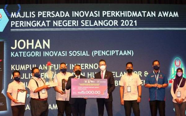 Chang Khim (empat dari kanan) menyampaikan hadiah johan kategori inavasi sosial (penciptaan) dimenangi oleh Majlis Perbandaran Hulu Selangor sempena SRIE 2021 pada Ahad.