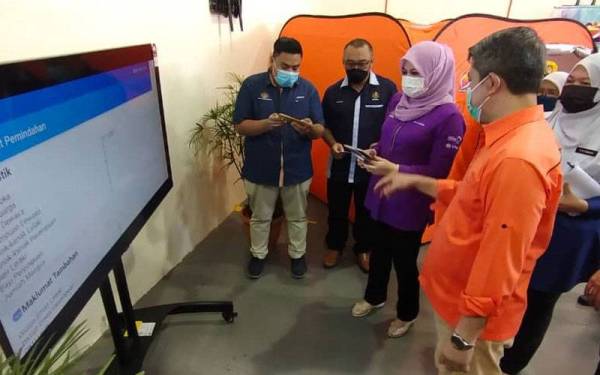 Rina (tiga kiri) diberikan taklimat berhubung InfoBencana JKM 2.0 yang dilancarkan pada Ahad.