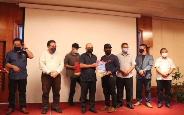 Ronald (tengah) menyerahkan watikah pelantikan myKP kepada ahli renjer Taman-taman Laut Wilayah Persekutuan Labuan sebaik selesai sesi libat urus itu.